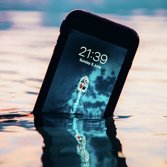 Catalyst iPhone waterproof case in black half submerged in water. 