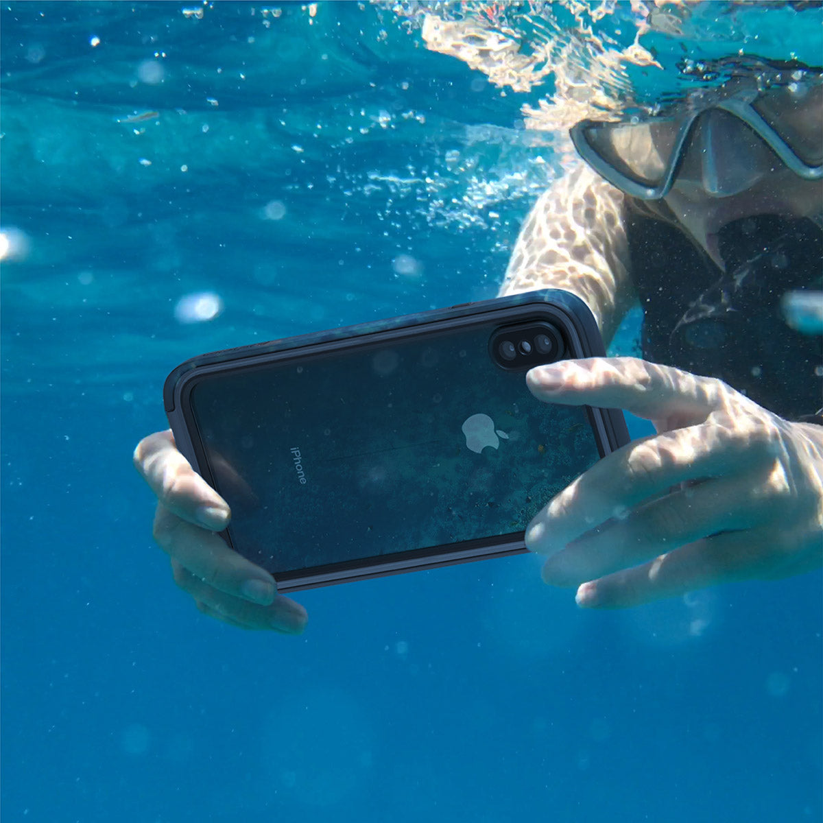 Catalyst iphone x/xr/xs/xs max waterproof case x showing a woman using her phone under water with the case in stealth black